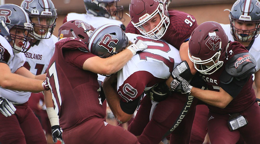 Puget Sound defenders wrap up a Redlands ballcarrier. (Photo by Andrew Glover, d3photography.com)