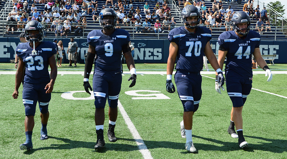 E.J. Lee, Vincent Ebron, Devin Miller and Andrew Eagle walking out for the coin toss for Wesley. (Wesley athletics photo)