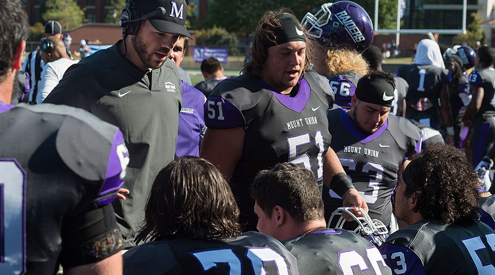Cole Parrish talks to his fellow offensive linemen on the sideline.
