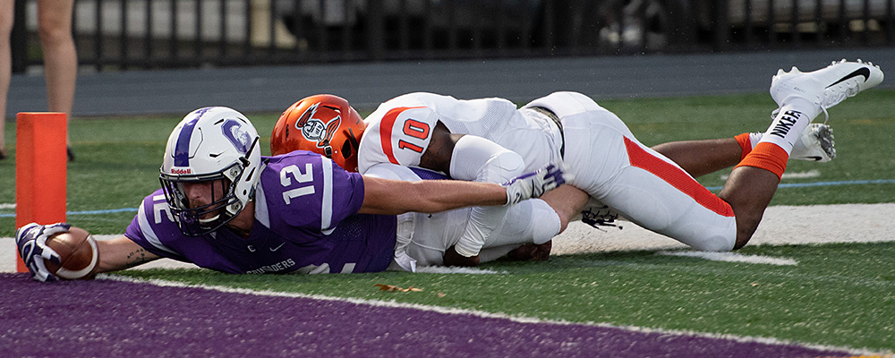 Wyatt Pertuset leans the ball over the goal line in front of the pilon for Capital in a game against Heidelberg. (Capital athletics photo by Spencer Dilyard)