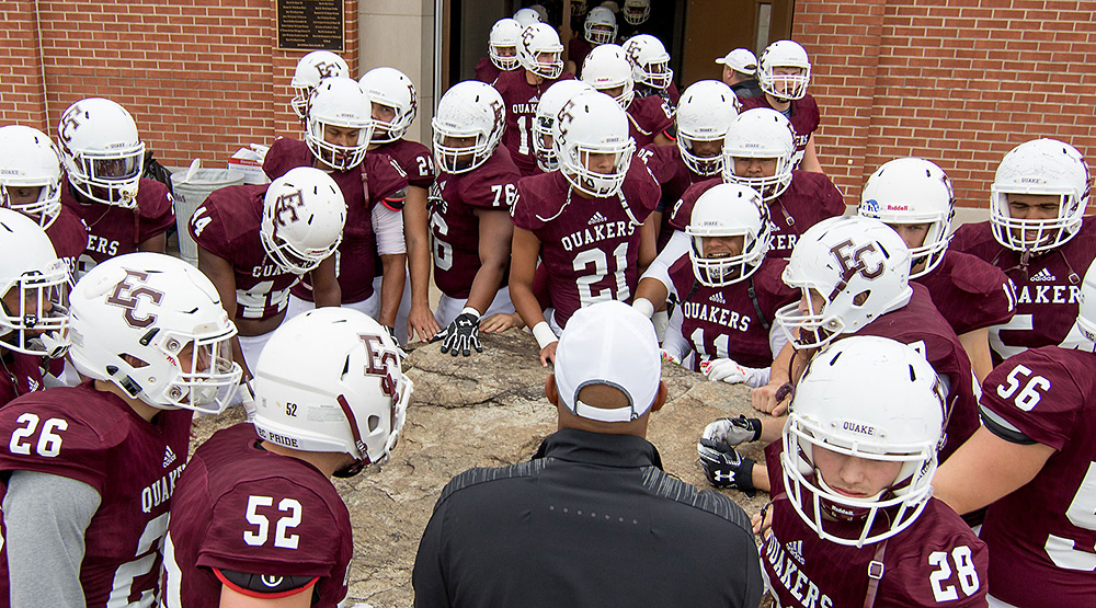 Earlham players standing around their rock. (Earlham athletics file photo)