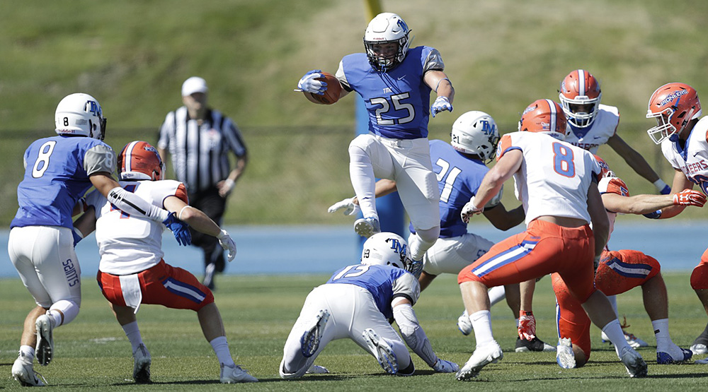 Thomas More's Luke Zajac hurdles over a teammate to try to pick up more yardage against UW-Platteville. 